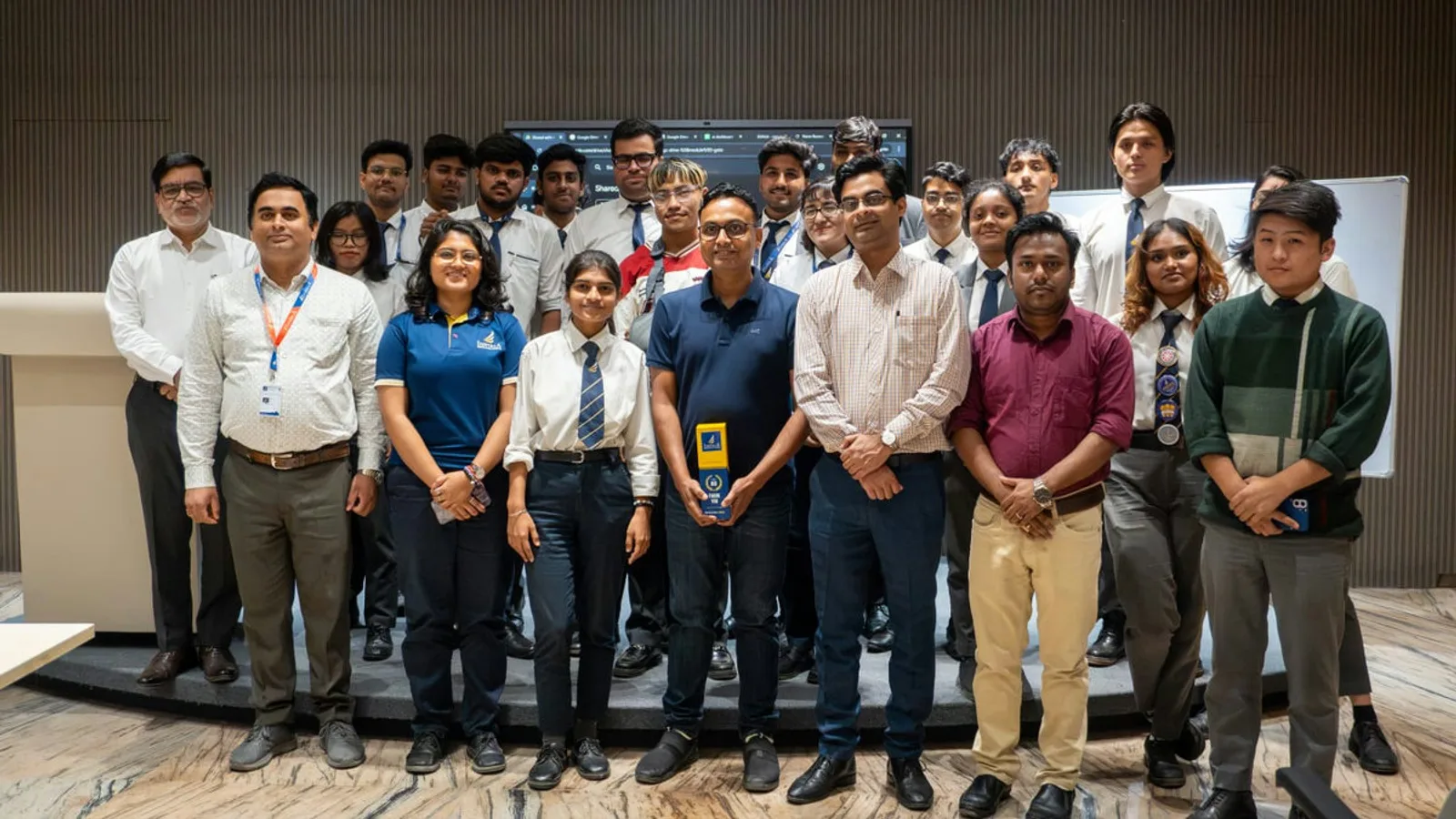 Rakesh Mondal with college students and faculty after an AI workshop, holding an appreciation award